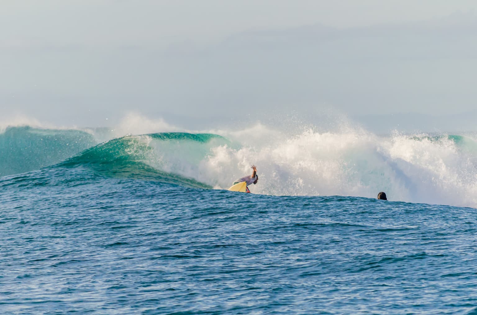Pansukyan wave wraps around the reef at surfer carves